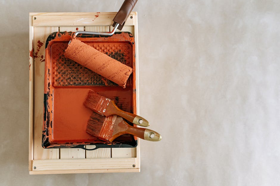 An overhead shot of paintbrushes and a roller in a tray, perfect for home renovation projects.