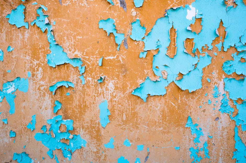 Vibrant wall featuring weathered blue and orange peeling paint with a textured surface.