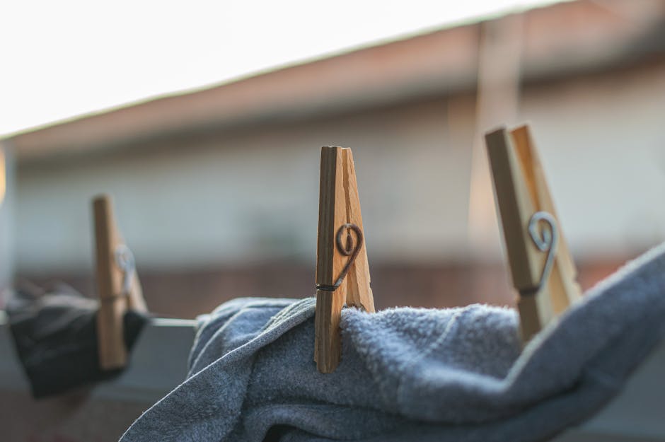 Wooden clothespins securing laundry on a line, outdoors in natural light.