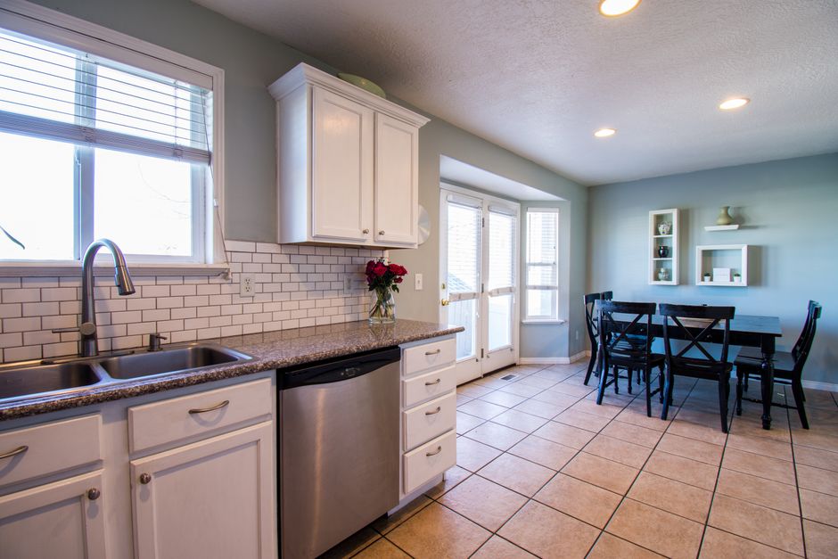 Spacious kitchen and dining area with natural light and modern decor.