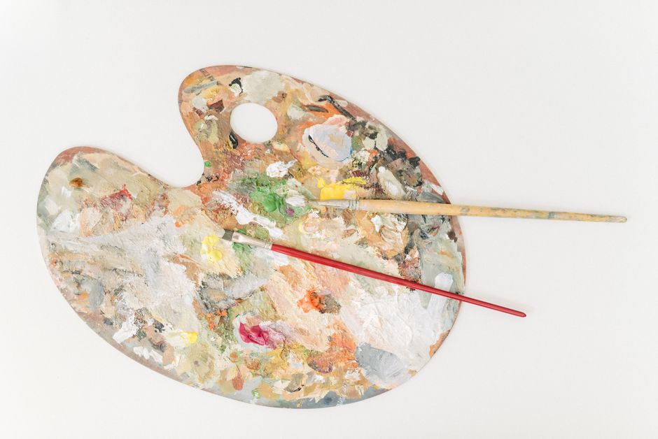 Vibrant artist's palette with colorful paint and brushes for creative projects.