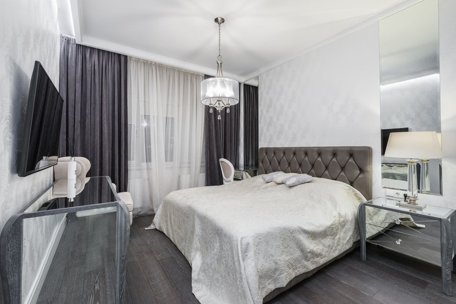 Spacious modern bedroom featuring a plush bed and elegant lighting, perfect for relaxation.