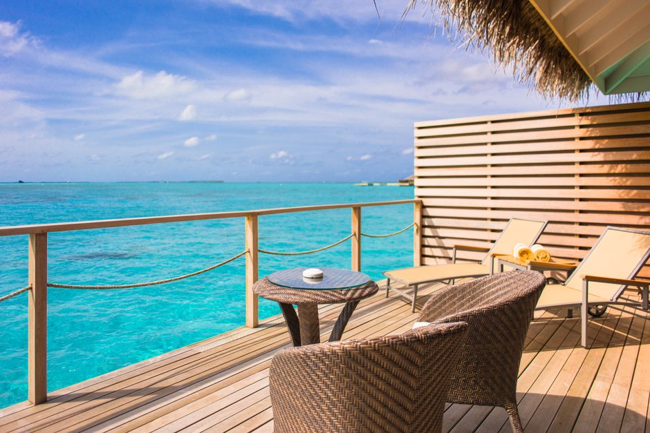 Wooden deck with weather-resistant wicker chairs by the sea